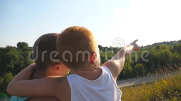 小男孩和他父亲坐在山上指着什么爸爸和他的小儿子在一起视频的预览图