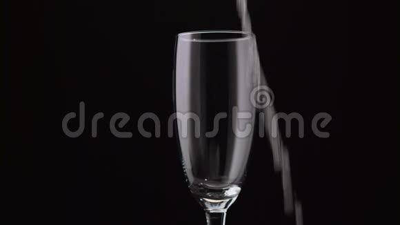 服务员把瓶子里的香槟倒进玻璃杯里黑色背景视频的预览图