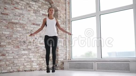 年轻和运动的女人在健身俱乐部里通过跳绳来锻炼肌肉视频的预览图