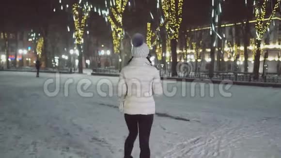 穿着冬天衣服的女孩在街上下雪视频的预览图