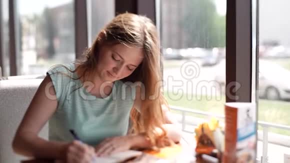 商务女性坐在办公桌的咖啡馆里填写一份文件女孩写了一支圆珠笔视频的预览图