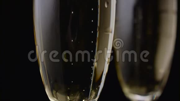 两杯香槟杯的气泡特写黑色背景视频的预览图