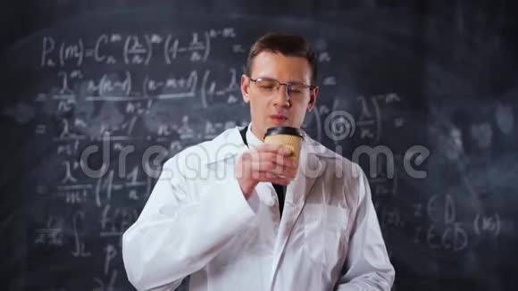 科学家身穿白色工作袍靠近粉笔板用方程式喝咖啡视频的预览图