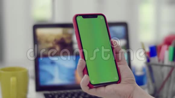 女人用智能手机看手机上的绿色屏幕视频的预览图