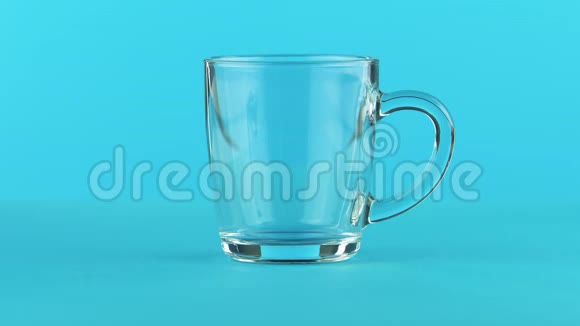 4K奶冷饮饮料的特写镜头用圆形手柄蓝底玻璃杯视频的预览图