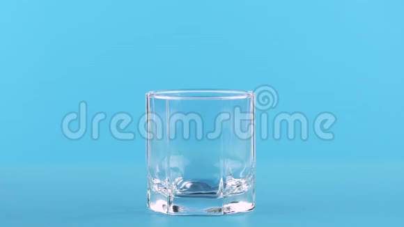 慢动作特写镜头牛奶冷饮饮料在工作室中用小面蓝色背景的玻璃制成视频的预览图