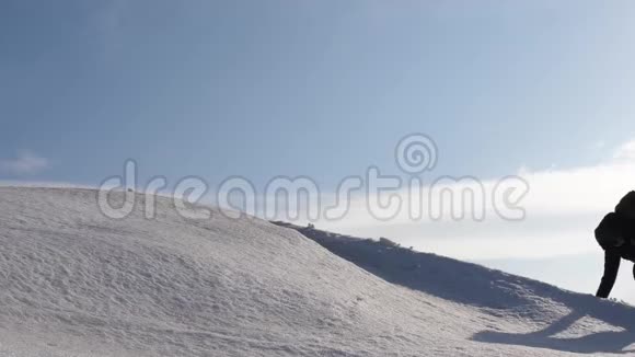 登山者手牵手爬到雪山顶上冬天的旅行者团队要达到克服困难的目标视频的预览图