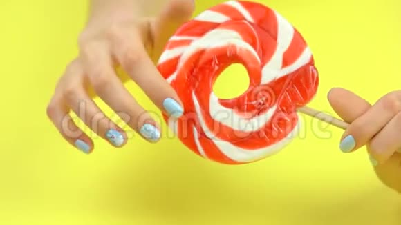 大的彩色棒棒糖在雌性手中移动视频的预览图