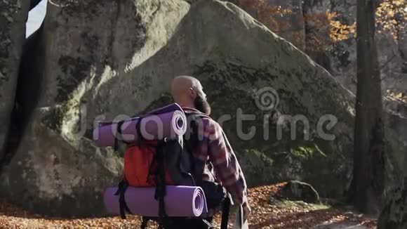 开朗的黑发游客穿着衬衫在笼子里背包走过森林秋天的旅游理念视频的预览图