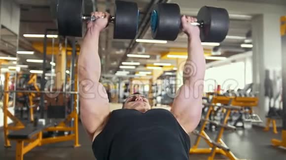 健身运动中的健美动作年轻肌肉男用哑铃训练二头肌视频的预览图
