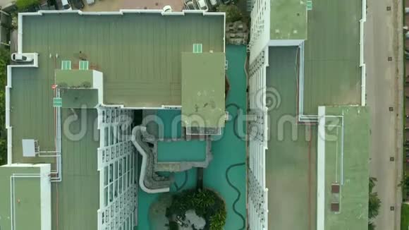 上景拍摄游泳池环绕棕榈和绿色花园在美丽的热带鸟瞰视频的预览图