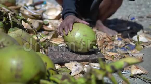 土著男子用大砍刀切椰子以获得一个年轻椰子的美味果汁当地的驼背人下来和排骨视频的预览图
