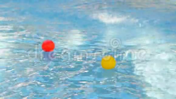 特写镜头水池里漂浮着两个小彩球在他们的顶部喷水从喷泉五彩缤纷视频的预览图