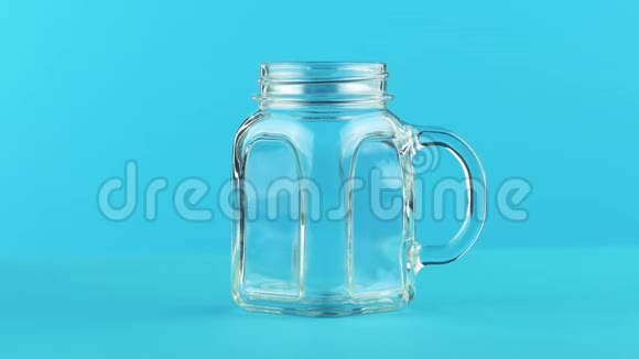 4K奶冷饮饮料的特写镜头画室内的玻璃罐杯蓝色背景视频的预览图