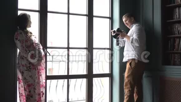专业摄影师拍摄窗户附近的怀孕模特视频的预览图