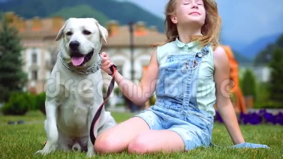 一个十几岁的女孩在公园里拥抱和玩她最喜欢的狗4k视频的预览图