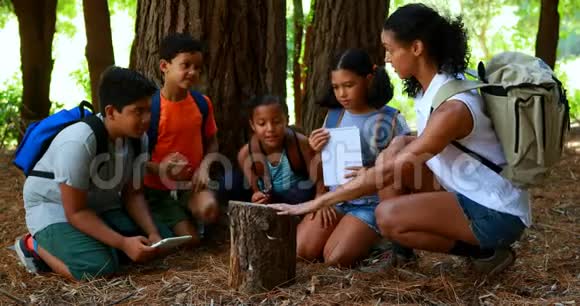 女人和孩子在公园里检查树木日志视频的预览图