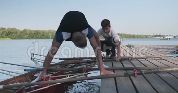 年轻的新手运动员带着双皮划艇青少年们把船放下水视频的预览图