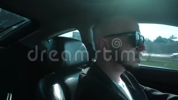年轻时尚男子戴着黑色太阳镜开车视频的预览图