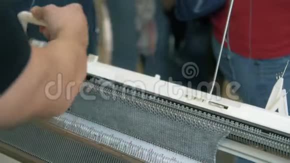 纺织厂织布机上手工制作针织纹理的工人在织布机上合上针织纱视频的预览图