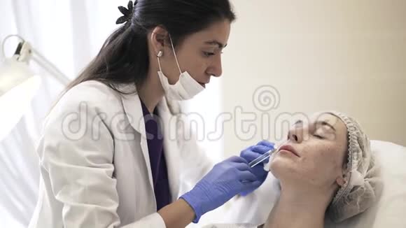 化妆师在女人的脸颊上打针视频的预览图