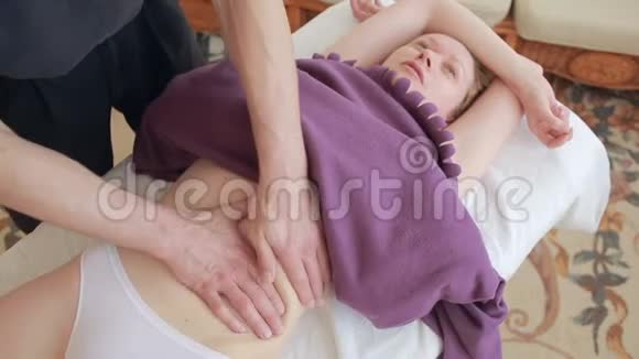 男性按摩师为女性做胃部按摩视频的预览图