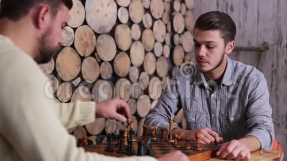 两个年轻的白种人正在下棋一个人赢得了比赛在游戏结束时握手视频的预览图