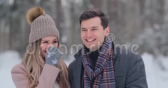 年轻的已婚夫妇相爱在冬天的森林里散步一男一女互相看着笑着进来视频的预览图