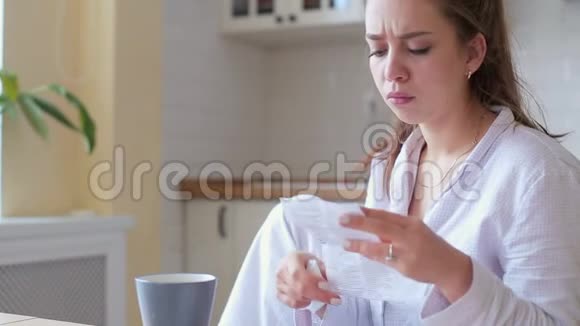 生病的年轻女人在家喝茶视频的预览图