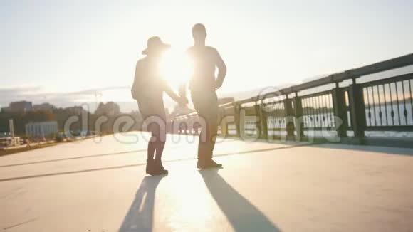 快乐的一对在户外玩得很开心的夫妇男人和女人在日落时跳舞视频的预览图