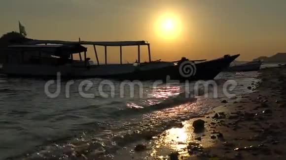 美丽的日落视频海滩与抛锚的游艇在远处游船在近岸靠岸视频的预览图