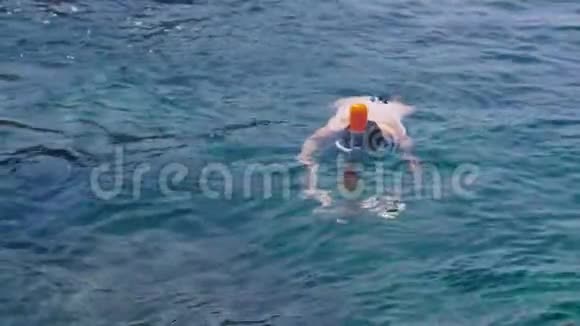 热带海洋中的年轻女子浮潜和用手机制作水下照片视频视频的预览图