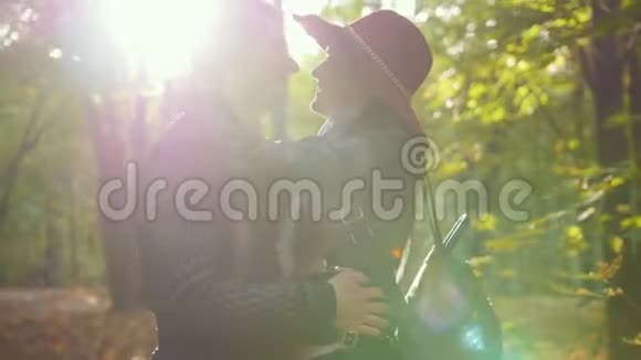 日落时分一对男女在秋日公园的阳光下亲吻视频的预览图