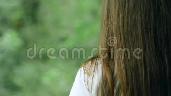 女孩白天在绿色森林里散步视频的预览图