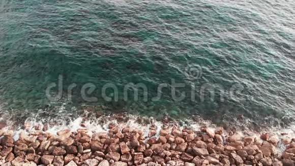 海浪撞击岩石海滩的空中景色一张清晰的蓝色海水视频的预览图