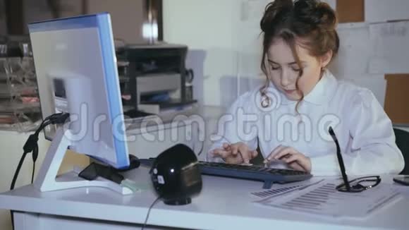 忙碌的微笑女孩在键盘上打字并使用图表4K视频的预览图