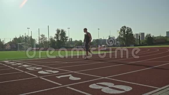 大胡子男运动员开始跑开始沿着跑道跑过足球场视频的预览图