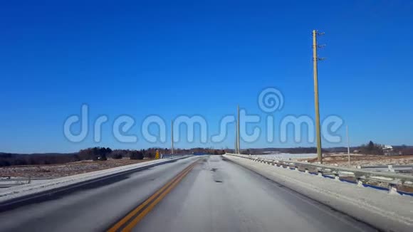 白天驾驶冬季农村公路司机的观点POV乡村街道与雪视频的预览图