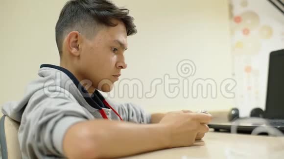 一个听力障碍的年轻人在智能手机上玩助听器视频的预览图