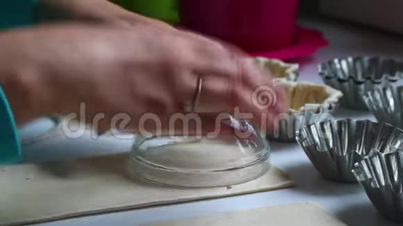 那个女人在一个圆碗的帮助下挤压出烤蛋糕的坯附近有烘焙字体空的和填充的w视频的预览图