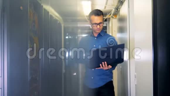 一个手提电脑的人站在服务器机房视频的预览图