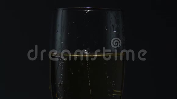 一杯香槟扔一个玫瑰花蕾黑色背景关门视频的预览图