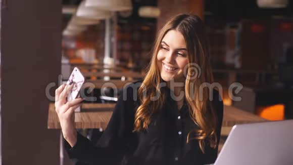 非常漂亮的白种人年轻女士穿着黑色衬衫在咖啡馆自拍视频的预览图