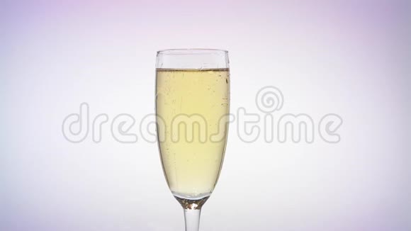 一杯香槟扔一个玫瑰花蕾白色背景视频的预览图