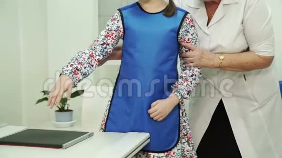 一位年迈的护士正在为一个小女孩准备X光刷视频的预览图