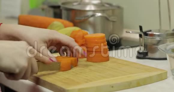 女家庭主妇用手把胡萝卜切成碎片视频的预览图