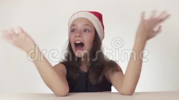 戴着圣诞老人帽子的漂亮少女情绪异常在白色背景股票上滚动歇斯底里视频的预览图