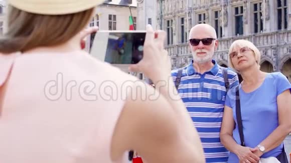 她的女儿在比利时布鲁塞尔中央广场的度假旅行中为她的父母拍照视频的预览图