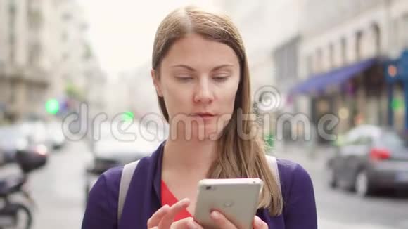 微笑的女商人站在街上使用智能手机专业女性浏览阅读新闻视频的预览图