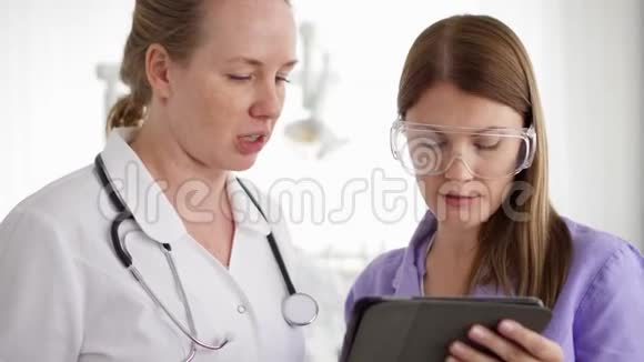 两个漂亮的女医生在医院的病房里讨论一些药片工作的医务人员视频的预览图
